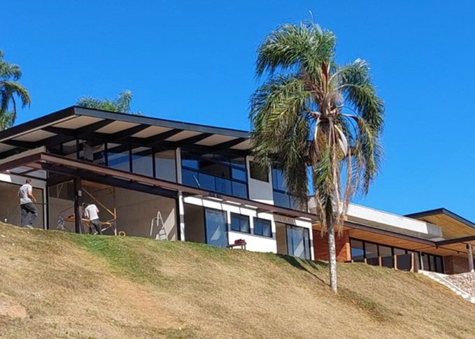 Residência em terreno inclinado com estrutura metálica e ampla cobertura